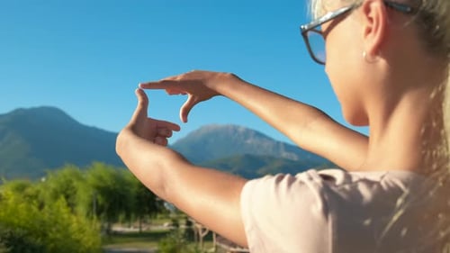 Woman Framing Scenic View with Fingers