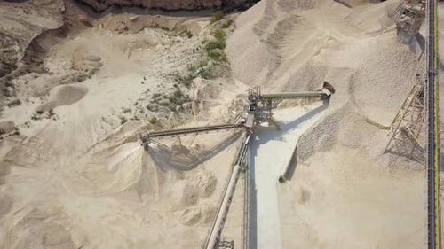 Stone sorting station in a large Quarry, with rocks transported on conveyor belts, Aerial view.