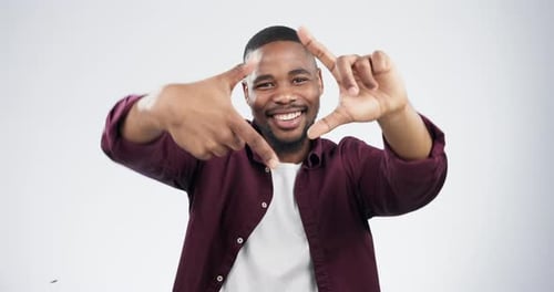 Happy Man Framing Face with Hands in Studio