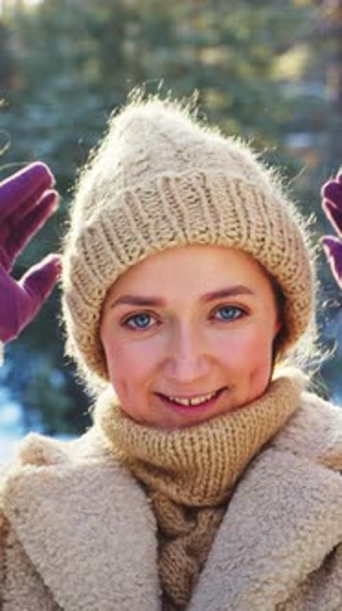 Woman smiling in winter forest, wearing knitted hat