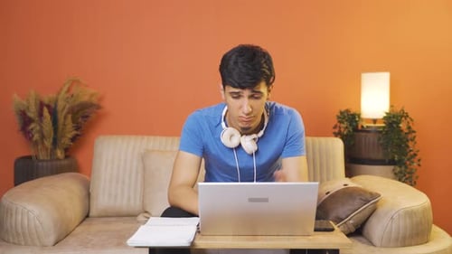 Young Adult Stressed While Working on Laptop at Home