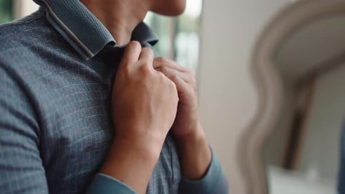 Young Man Buttons Dress Shirt in Mirror