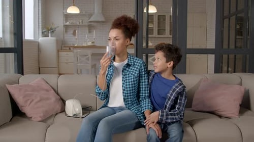 Woman Using Nebulizer with Child in Home