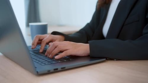 Geschäftsfrau aus nächster Nähe, die auf einem Laptop tippt und im modernen Büro arbeitet