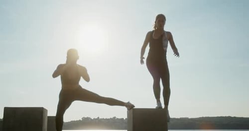 Women Exercising on Concrete Blocks by Water