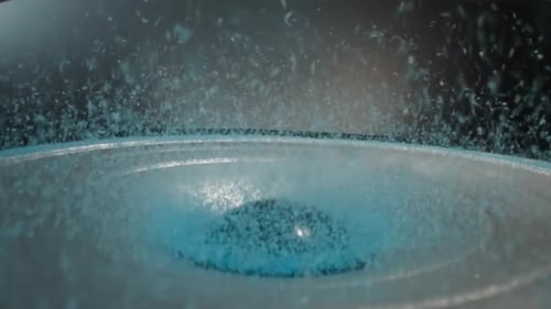 Blue Sand Put on Edge of Shaking Speaker and Flows to Center