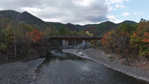 The Car is Driving Over a Bridge in the Mountains