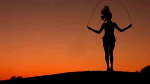 Woman Jumping Rope Silhouette at Sunset