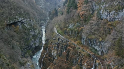 Top Down Aerial Drone View of Water Stream Flowing Along Rocky Ravine in Mountain Woods. High View o