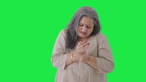 Sick Indian old woman suffering from arthritis Green screen