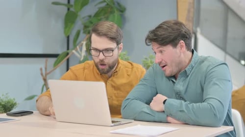 Men High-Fiving While Using Laptop in Office