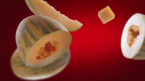 Cantaloupe Fruit Pieces Floating on a Red Backdrop
