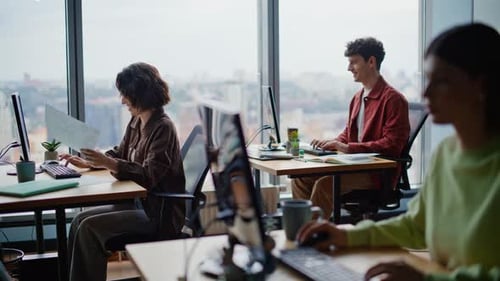 Lachende Büroangestellte, die im Freien arbeiten, Kollegen am Arbeitsplatz, kommunizieren