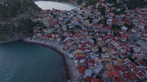 Aerial view of medieval town by turquoise sea at sunset, Greece.