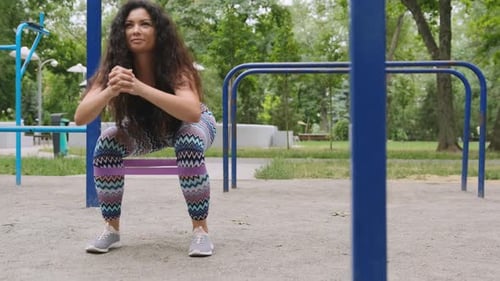 Athletic Woman Doing Squats with Resistance Band