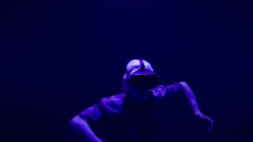 Person Dancing in VR Headset with Colorful Lighting