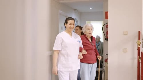 Medical Worker Assists Senior Woman with Cane