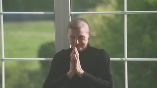 Woman Doing Arm Stretches in Front of Window