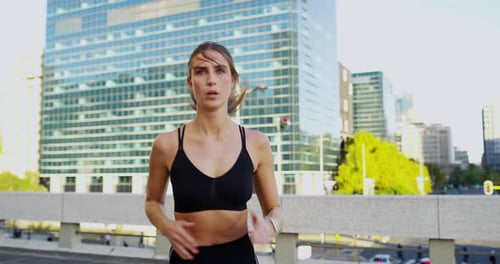 An attractive young woman out jogging in the city