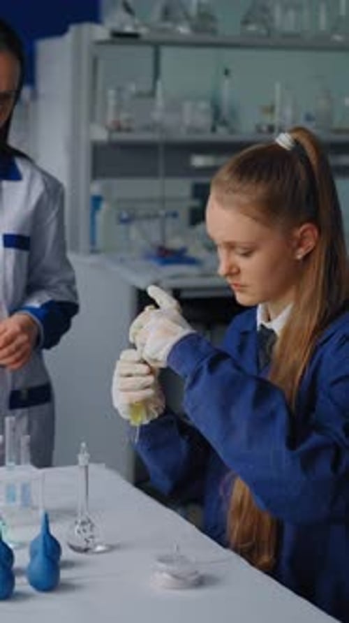 Child in Lab Coat Pours Liquid in Beaker
