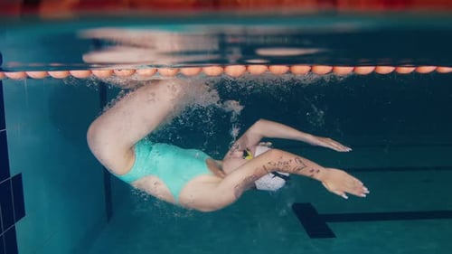 Professionelle Schwimmerin trainiert im Pool Unterwasserblick Schwimmerin dreht sich im Pool und