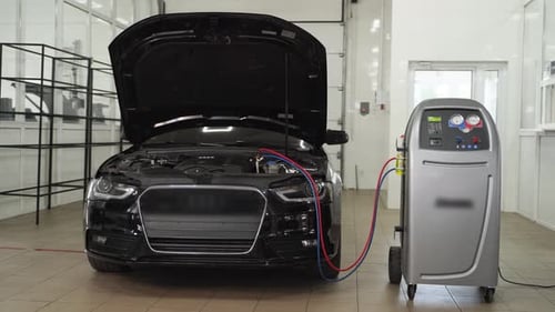 Car Undergoes AC Servicing with Refrigerant Recharge at Auto Repair Shop Technician Maintains