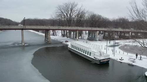 Flying away from small touristic boat in frozen river