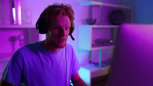 Young Man Plays Video Game with Headset On