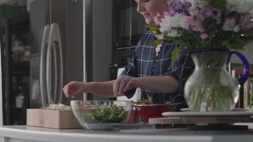 Woman Prepares Fresh Salad in Modern Kitchen