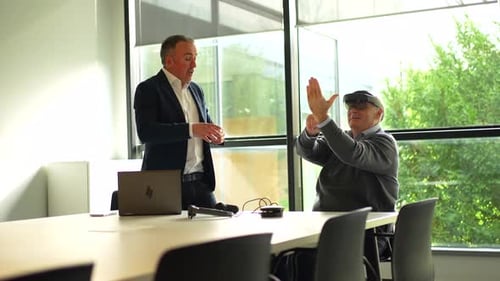 Senior Man Experiences VR in a Bright Office
