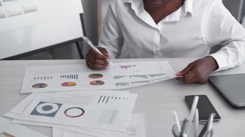 Adult Reviews Financial Charts in Office Workplace