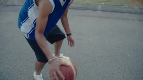 Jeune joueur de basket-ball dribble sur un terrain extérieur