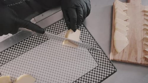 Chef with culinary skills cuts pieces of gourmet cheese for appetizer board. Restaurant. Recipe. Arg