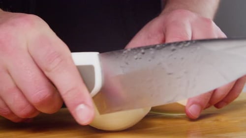 Raw Onion Sliced on Cutting Board with Knife