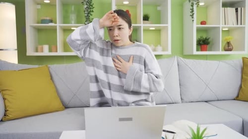 Young Woman with Symptoms Sits at Laptop