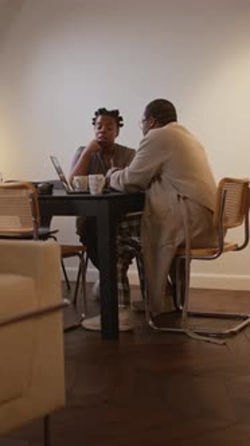 Woman and Man Working Together at Table Indoors