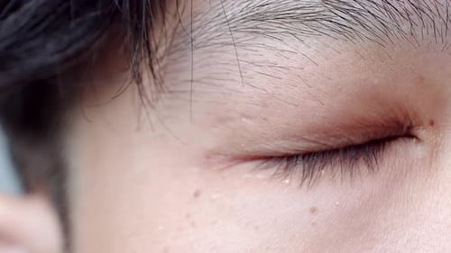 Close up of Asian Man's face. Attractive boy with beautiful eyes. Caucasian young male model with ey