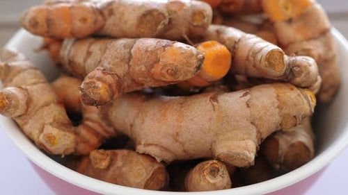 Racines de curcuma dans une assiette sur une table