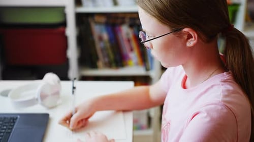 Focused Girl Studying at Her Desk with Laptop