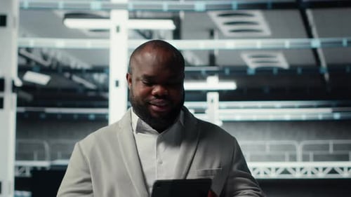 Fröhlicher Rechenzentrumsprogrammierer verwendet Tablet zur Verwaltung von Softwareupdates