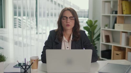 Woman Meditating at Desk in Bright Office