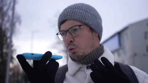 Man With Beanie Talking on Mobile Phone Outdoors