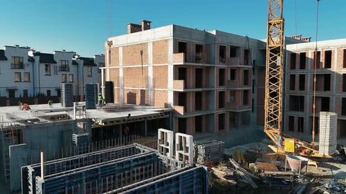 Construction Site with Workers Crane and Partially Built Multistory Building Surrounded By Equipment