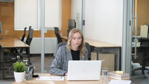 Woman Reviews Financial Data at Modern Office Desk