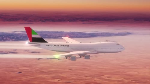 Commercial Airliner Passanger Plane Flying Over Desert At Sunset Country Flag United Arab Emirates