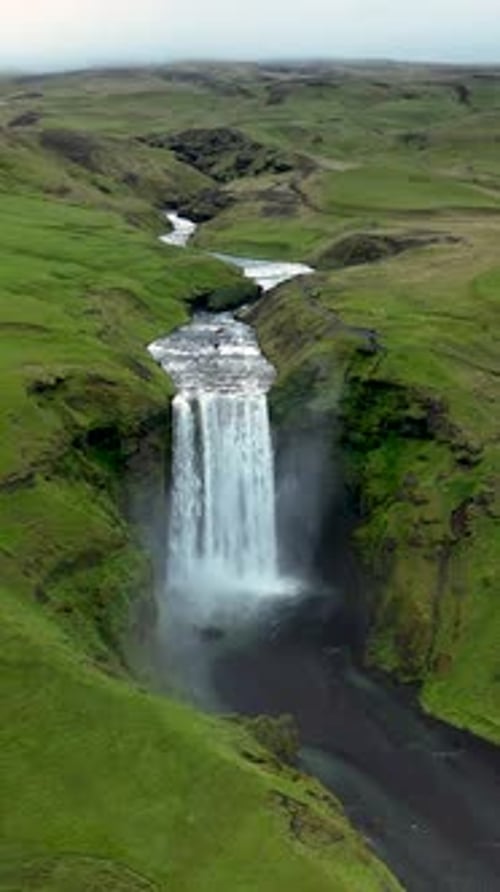 Explore the Majestic Skogafoss Waterfall Cascading Over Lush Green Cliffs in Iceland