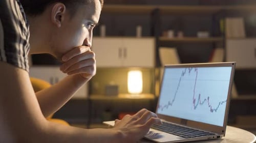 Young man examines cryptocurrency chart.