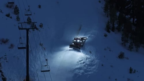Aerial Close Up Snowcat Grooming Ski Run at Night