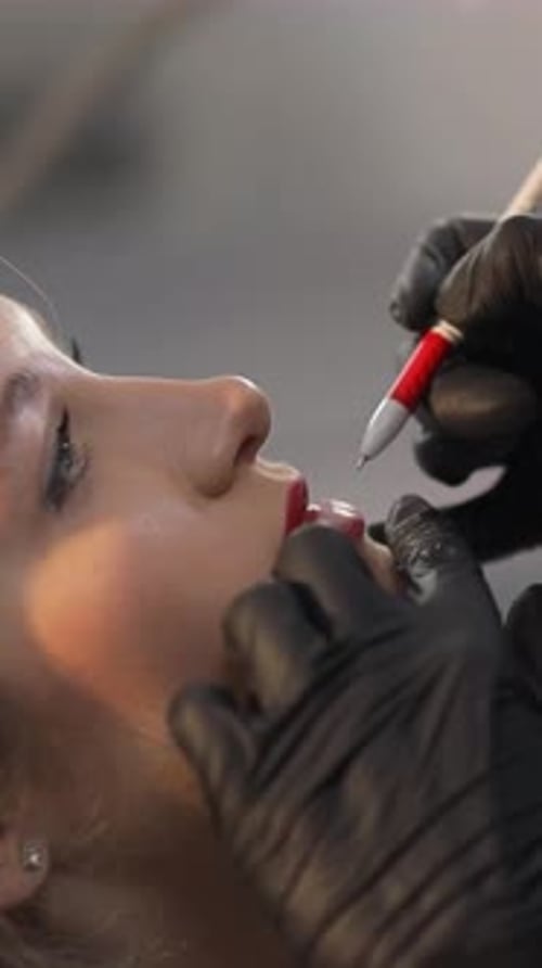 Woman receiving lip blushing procedure close up