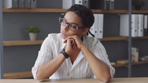 Thoughtful Woman in Office Contemplating Business